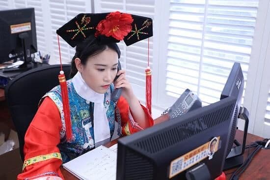 身著清宮古裝的華興保險員工在座位上接聽電話