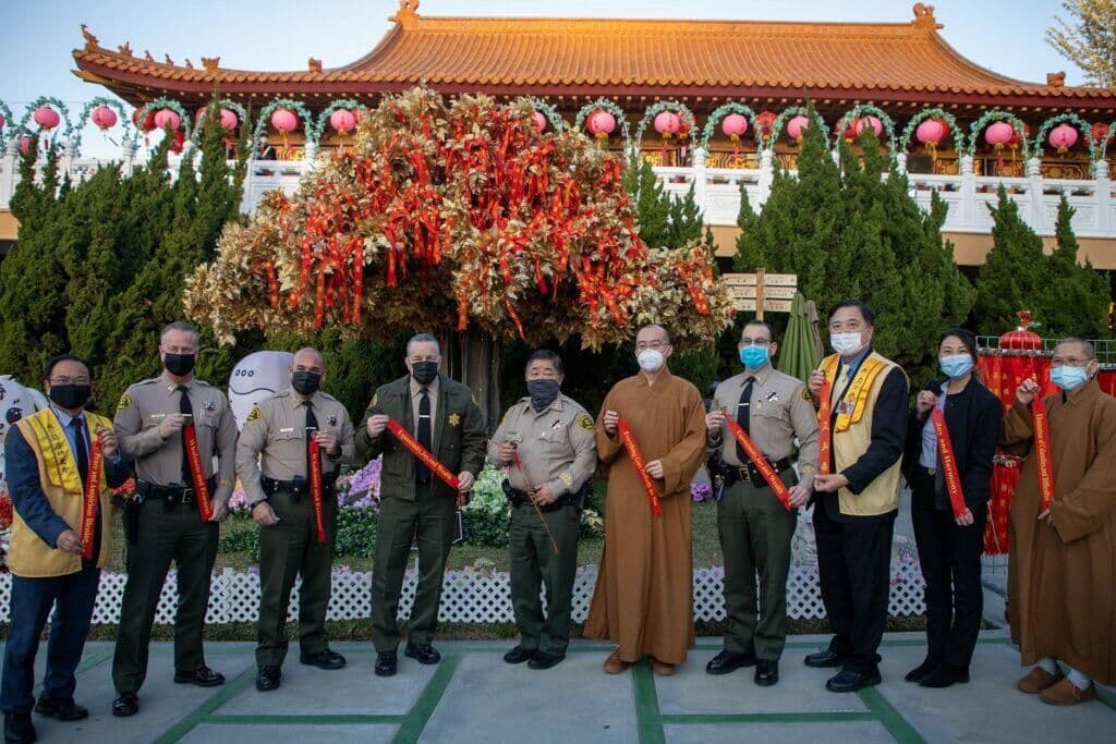 洛县警察局代表团、社区领袖与法师在西来寺手持祈愿带合影