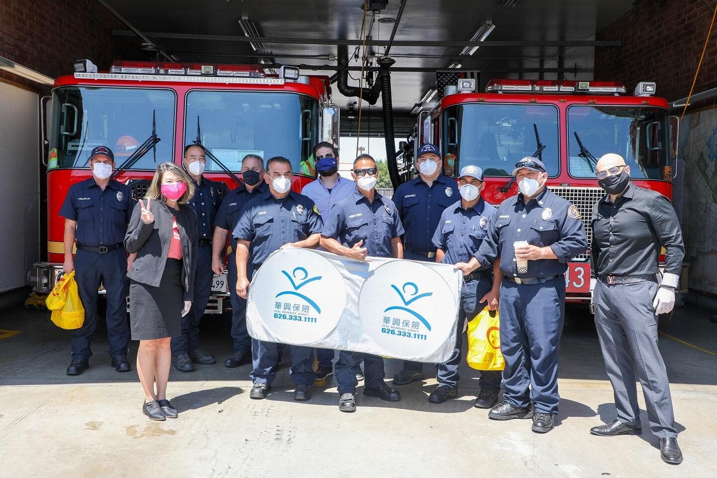 Firefighters with the KCAL Insurance banner after the lunch delivery