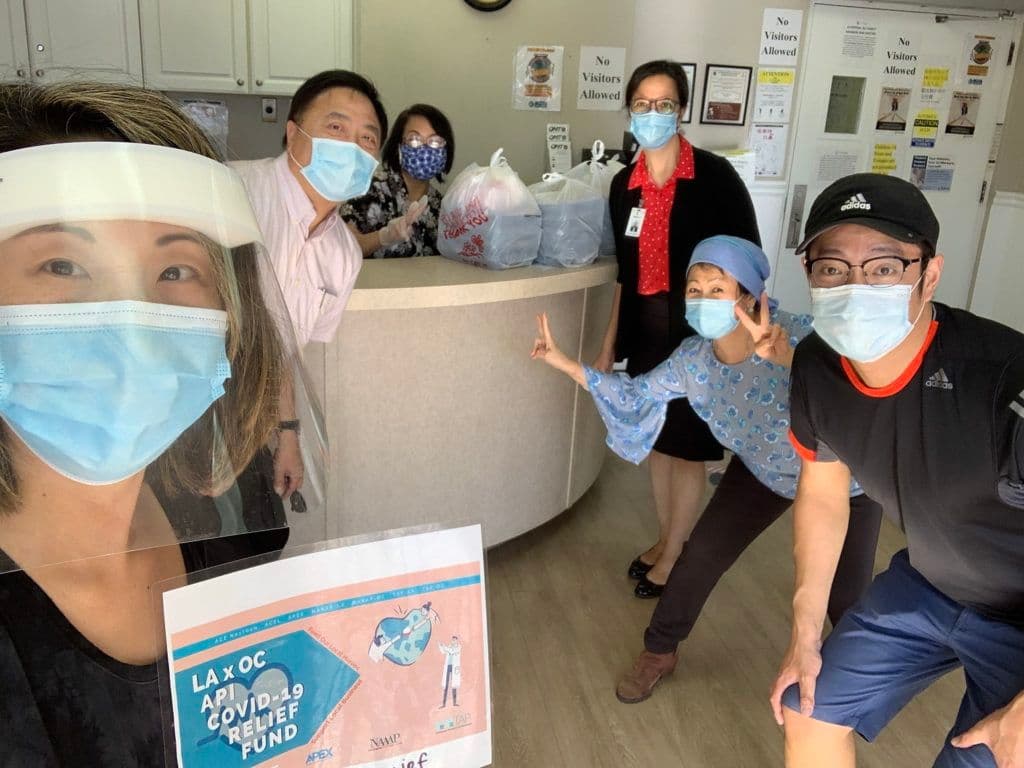 志工与Sunny Village Care Center员工手持纾困金计划标牌合影
