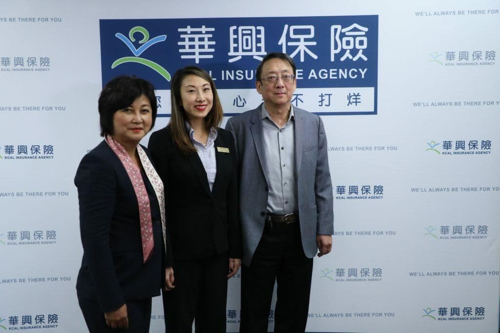 讲座讲者在华兴保险背板前合影