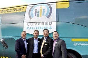 Covered California Executive Director Peter Lee and KCAL President Kenny Chang with guests beside the Covered California bus