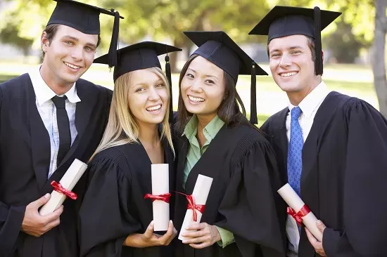 Four graduates in caps and gowns